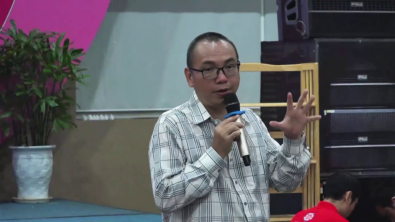 Diễn giả minh họa các bước tính toán và lựa chọn chữ cái khi đặt tên mới trên slide trình chiếu, giúp khán giả dễ hình dung.