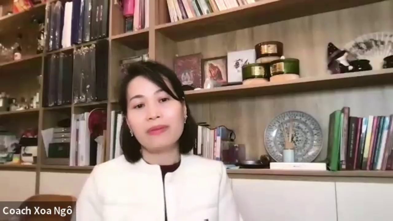 Một người phụ nữ đang ngồi làm việc tại bàn, xung quanh là sổ sách, kế hoạch được sắp xếp ngăn nắp.