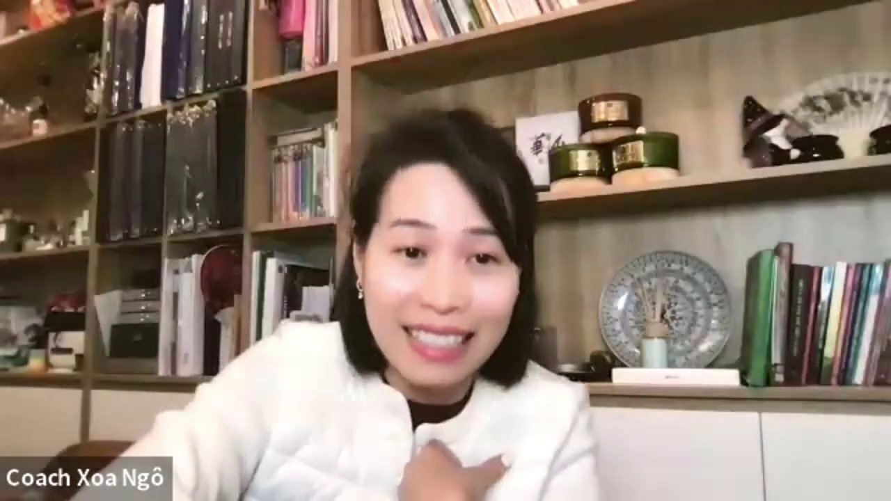 Một người đang nói chuyện tự tin trước đám đông, tay cầm micro.