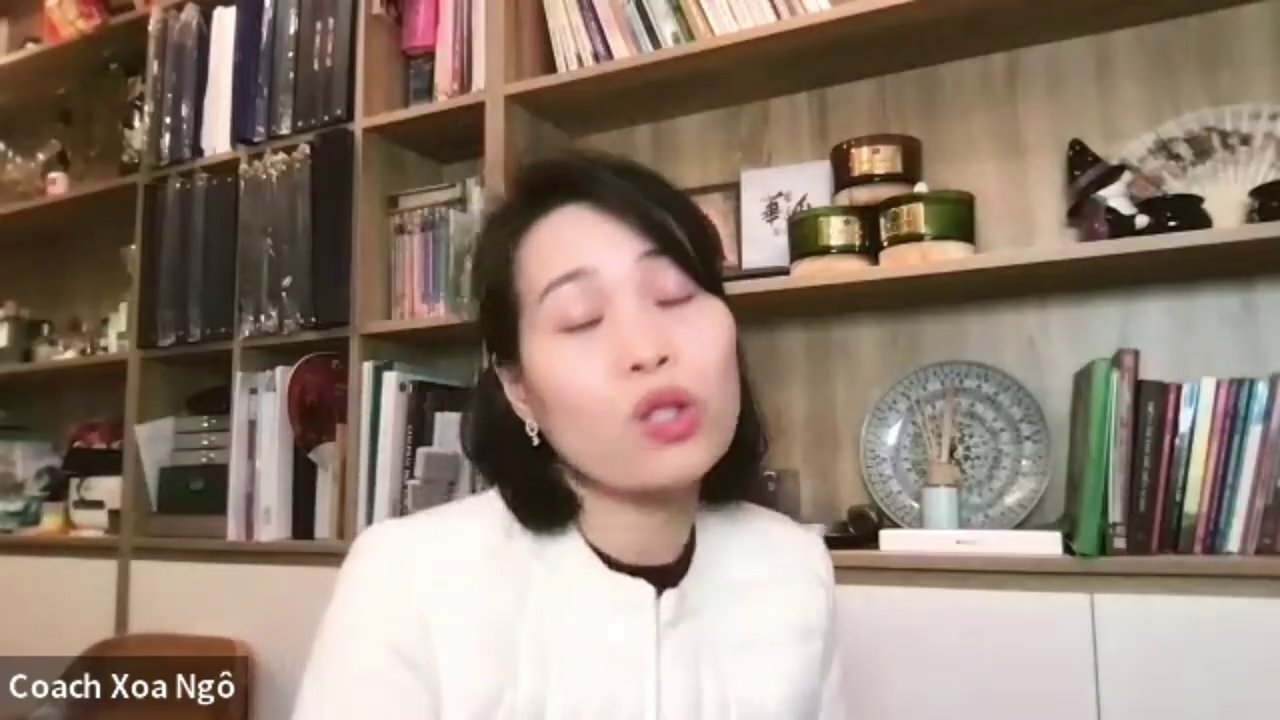 Một người đang đứng trên đỉnh núi, dang rộng hai tay đón gió, phía sau là khung cảnh hoàng hôn rực rỡ.